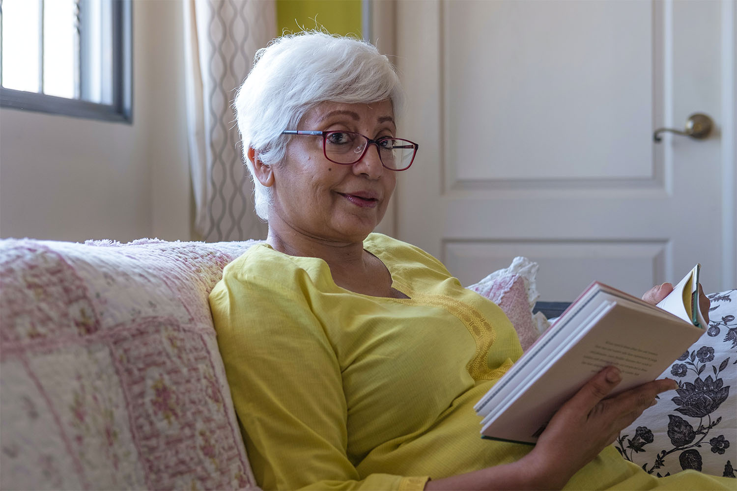 Lady reading a book at Silverleigh Care Home whilst staying for Respite Care.