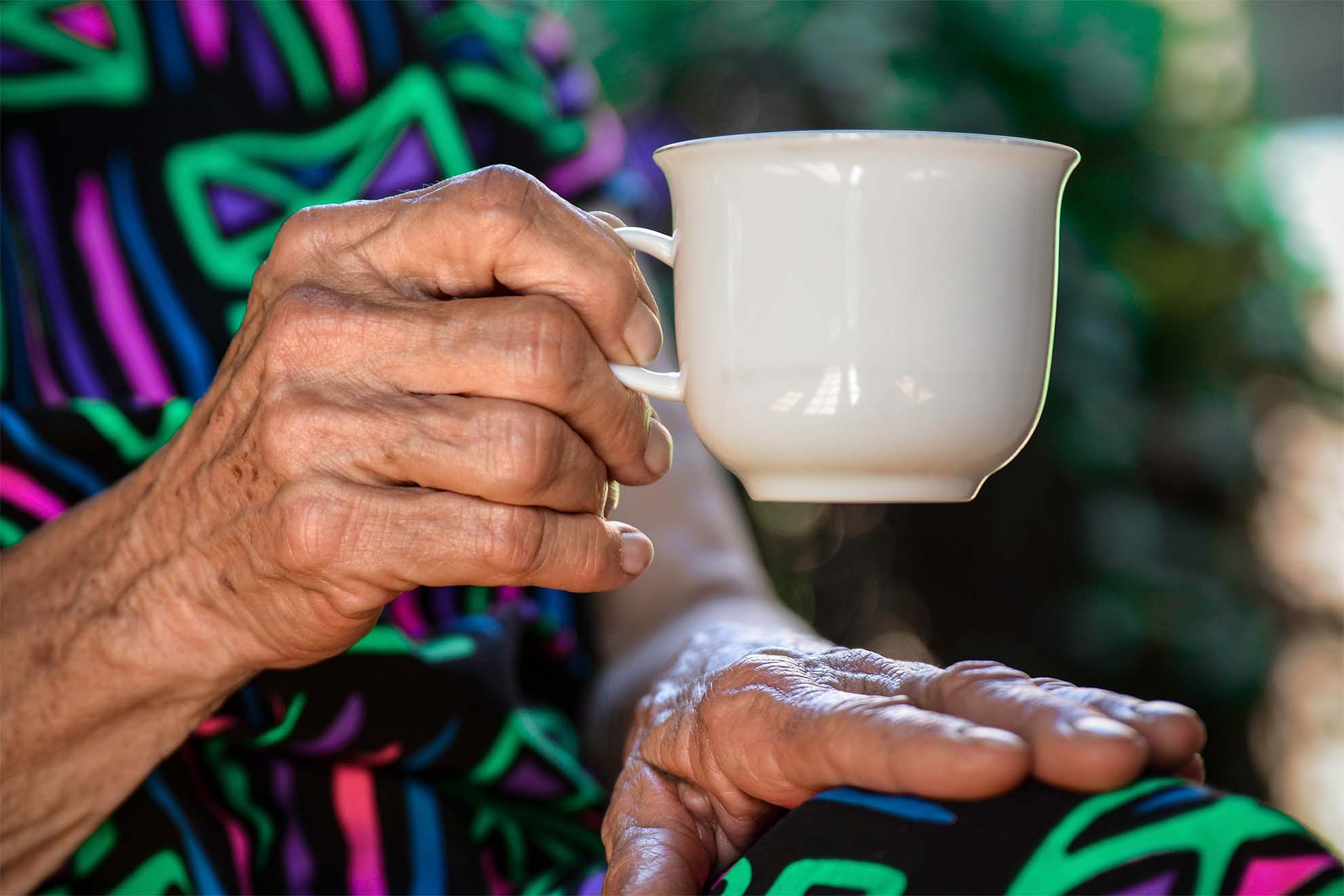 Resident holding a cup of tea.