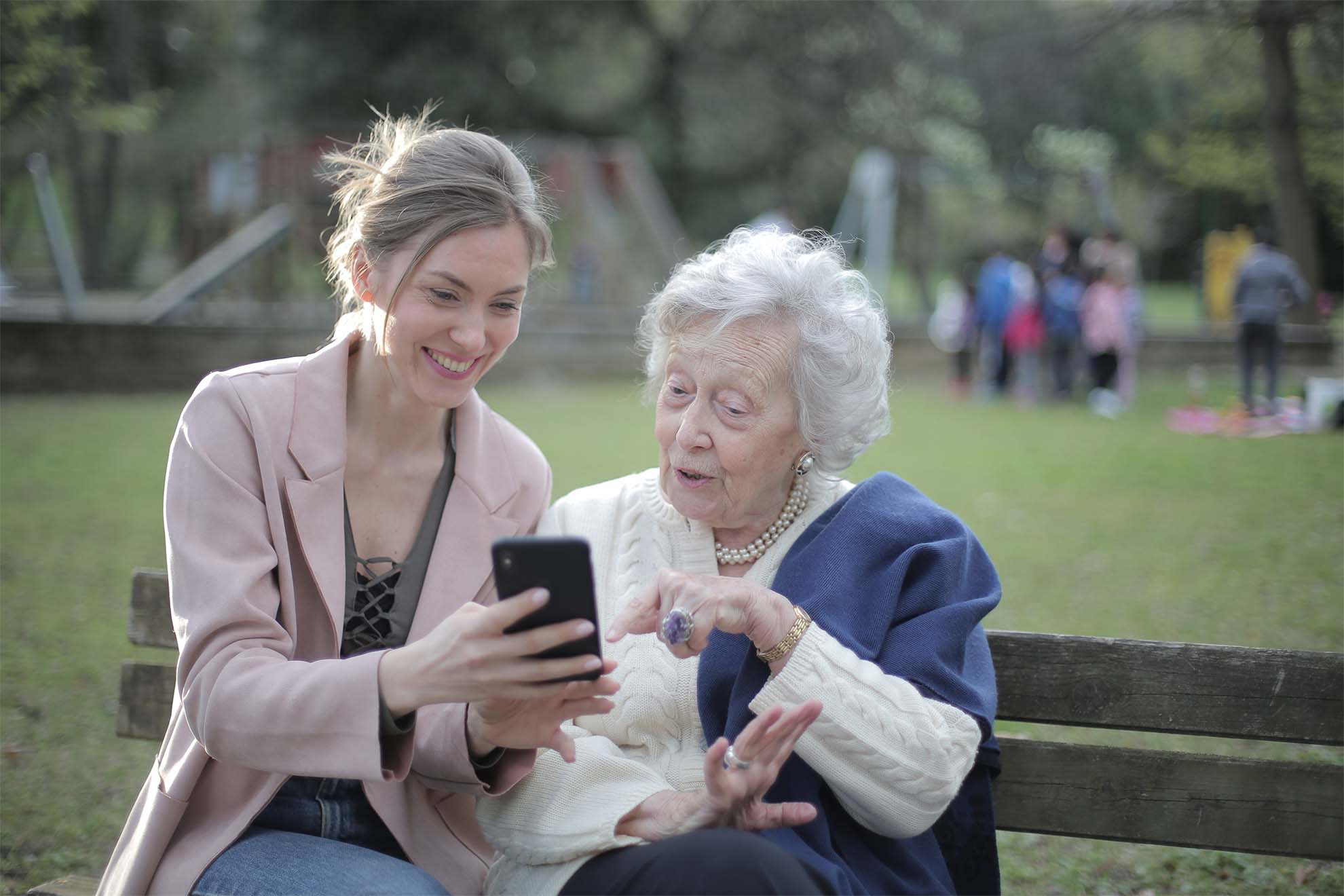 Resident and loved one looking and laughing at a phone.