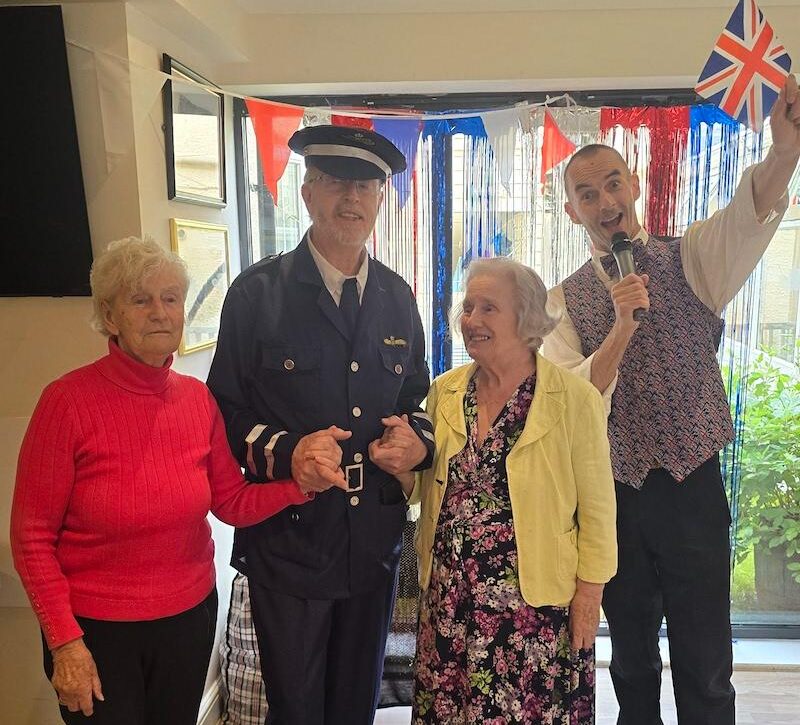 man stood with his wife and an entertainer in his uniform on VE day