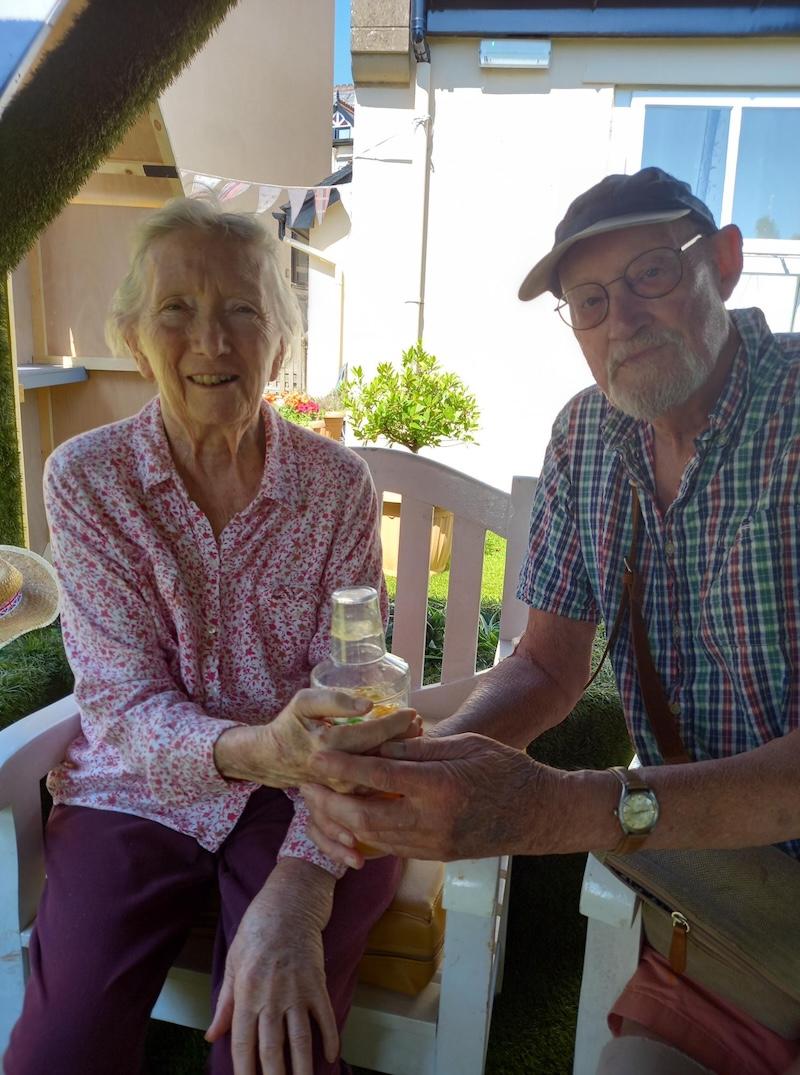 residents sat smiling holding a cocktail shaker together