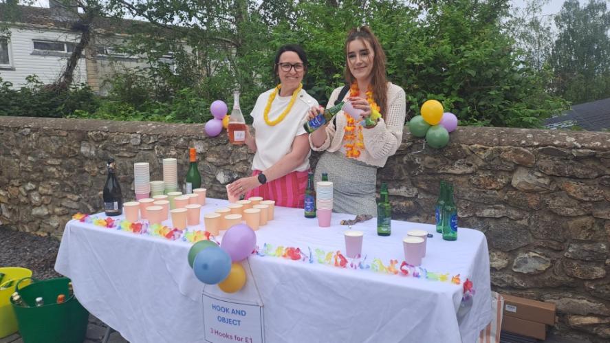 two ladies at a table pouring drinks